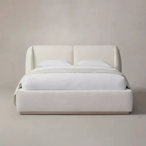 Modern minimalist beige upholstered bed with white bedding against a neutral background.