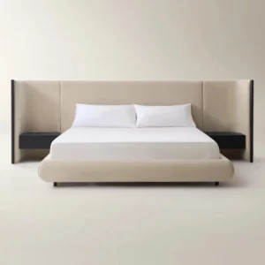 Beige upholstered bed with extended headboard and built-in black nightstands in a minimalist bedroom.